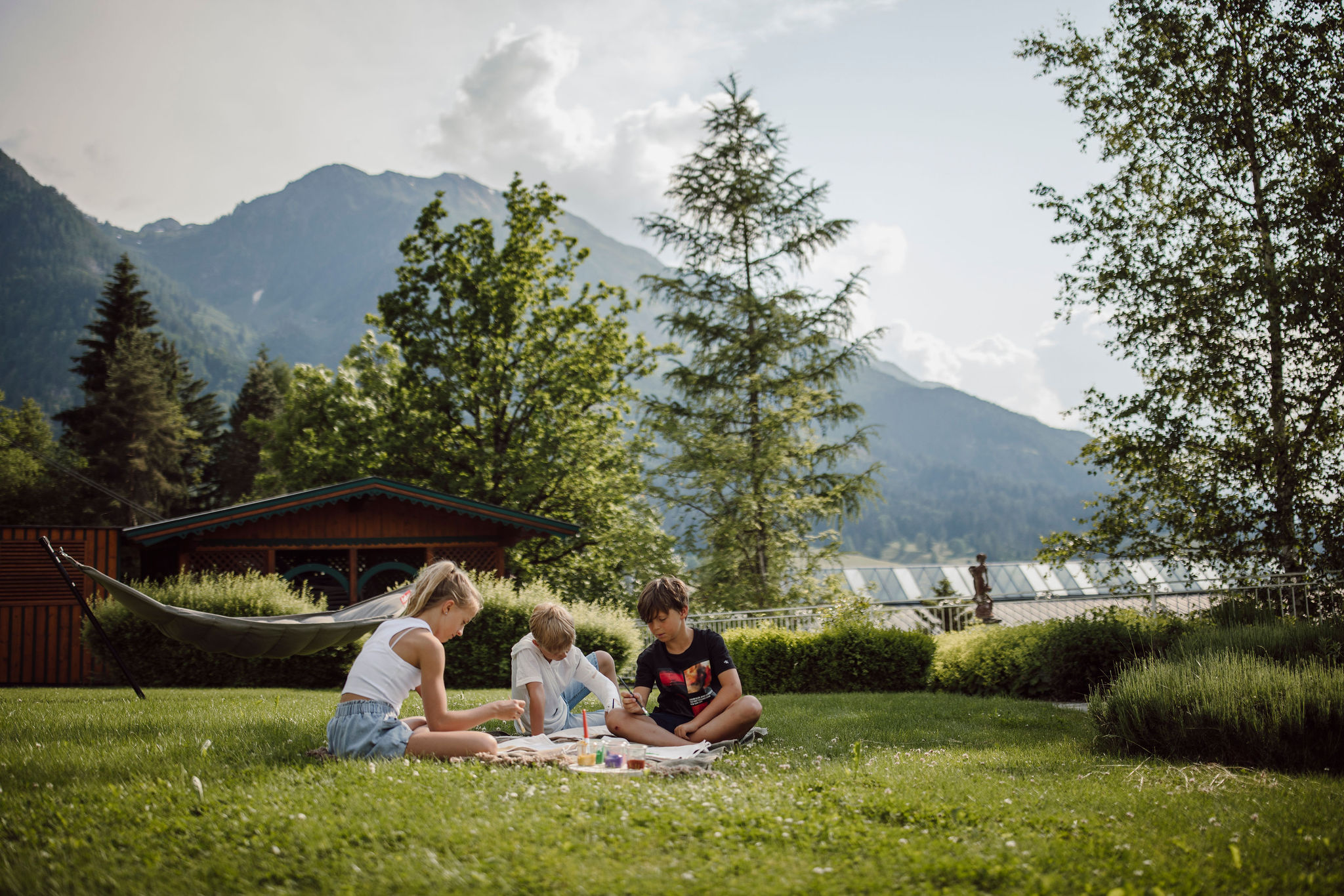 Kinder beim Malworkshop auf der grünen Wiese im Familienhotel Alpina Alpendorf