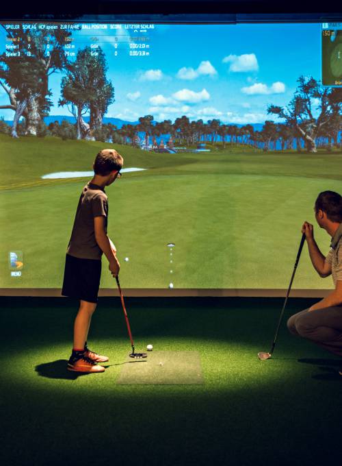 Kind bei der Indoor Golfanlage im Alpina Alpendorf