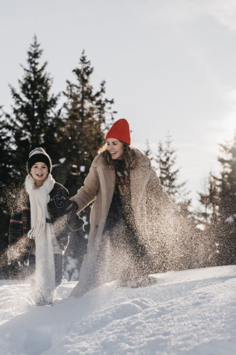 Mama und Kind haben Spaß im Schnee und in der Winterlandschaft rund ums Alpina Alpendorf