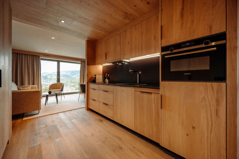 Zimmer, modern eingerichtet und gemütlich mit viel Holz und einer Küche im Alpina Alpendorf