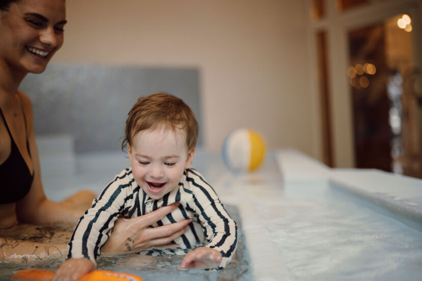 Mama plantscht mit ihrem Baby im beheiztem Babybecken im Familienhotel Alpina.