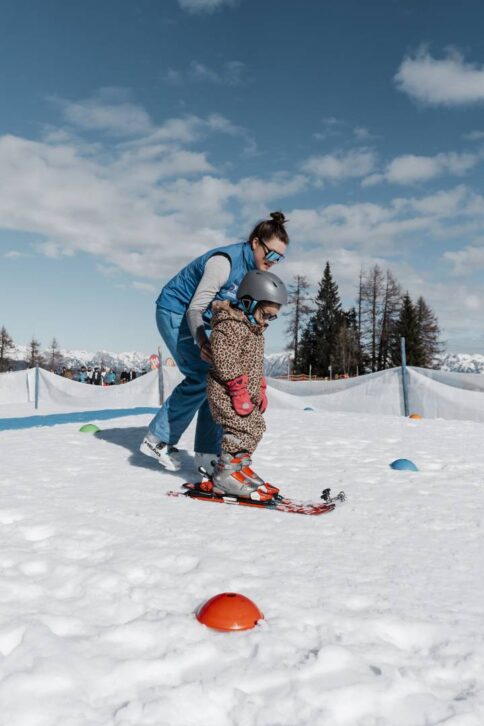 Ein Maedchen lernt das Skifahren beim Familienskiurlaub im Alpina