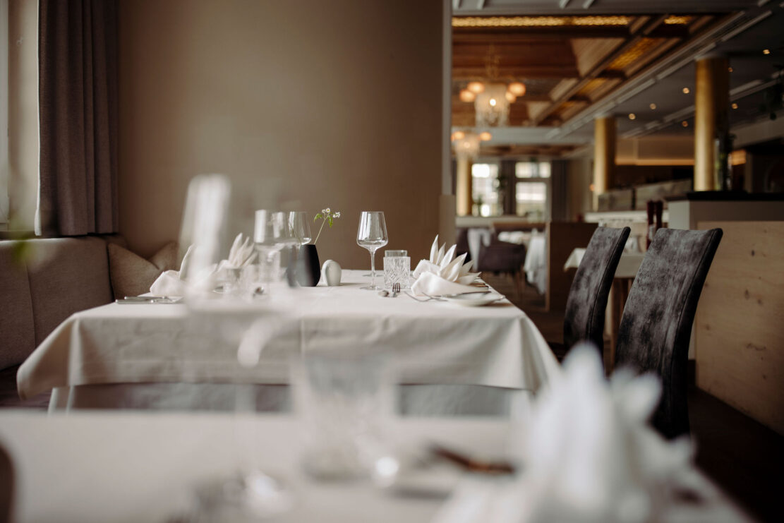 Elegantes Restaurant im Hotel Alpina Alpendorf mit gedeckten Tischen