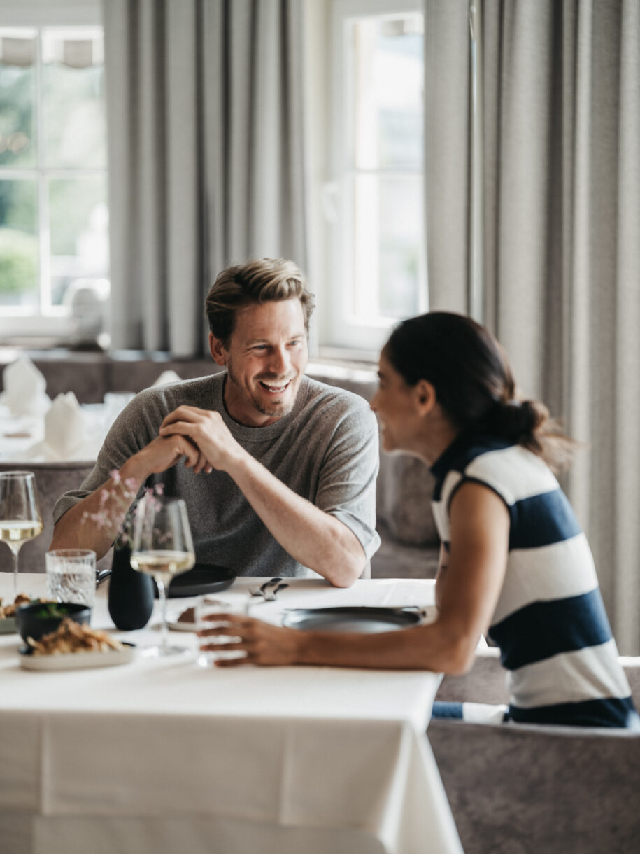 Ein Paar genießt das Dinner im Restaurant im Alpina Alpendorf im Salzburger Land