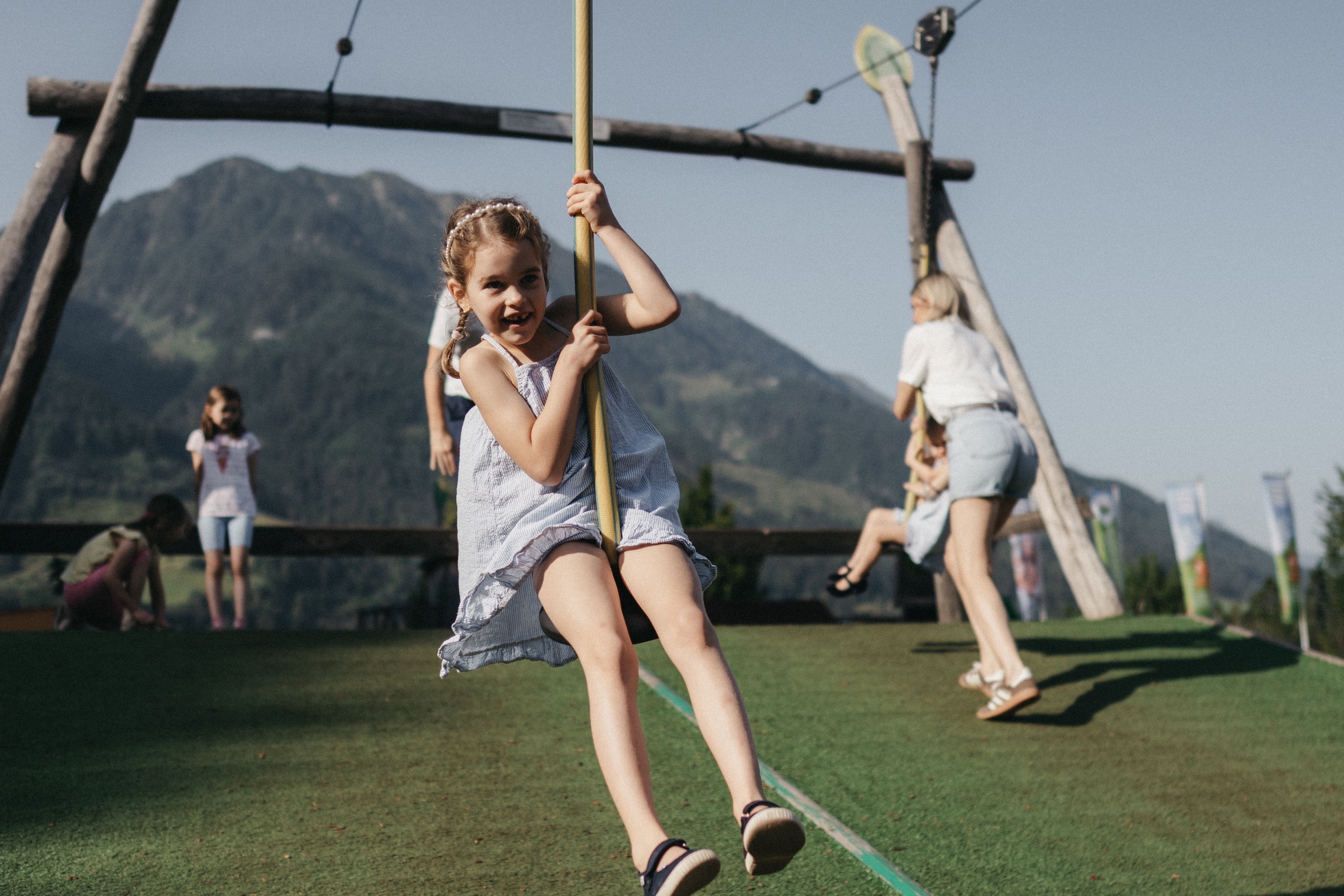 Eine Familie verbringt den Sommertag am Spielplatz beim Hotel Alpina.