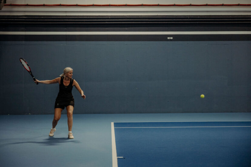 Eine Frau beim Tennistraining im Tennishotel Alpina Alpendorf.