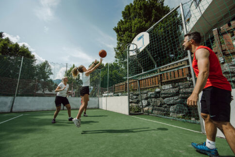 Eine Familie spielt Basketball am Funcourt direkt vor dem Hotel Alpina in Salzburg.