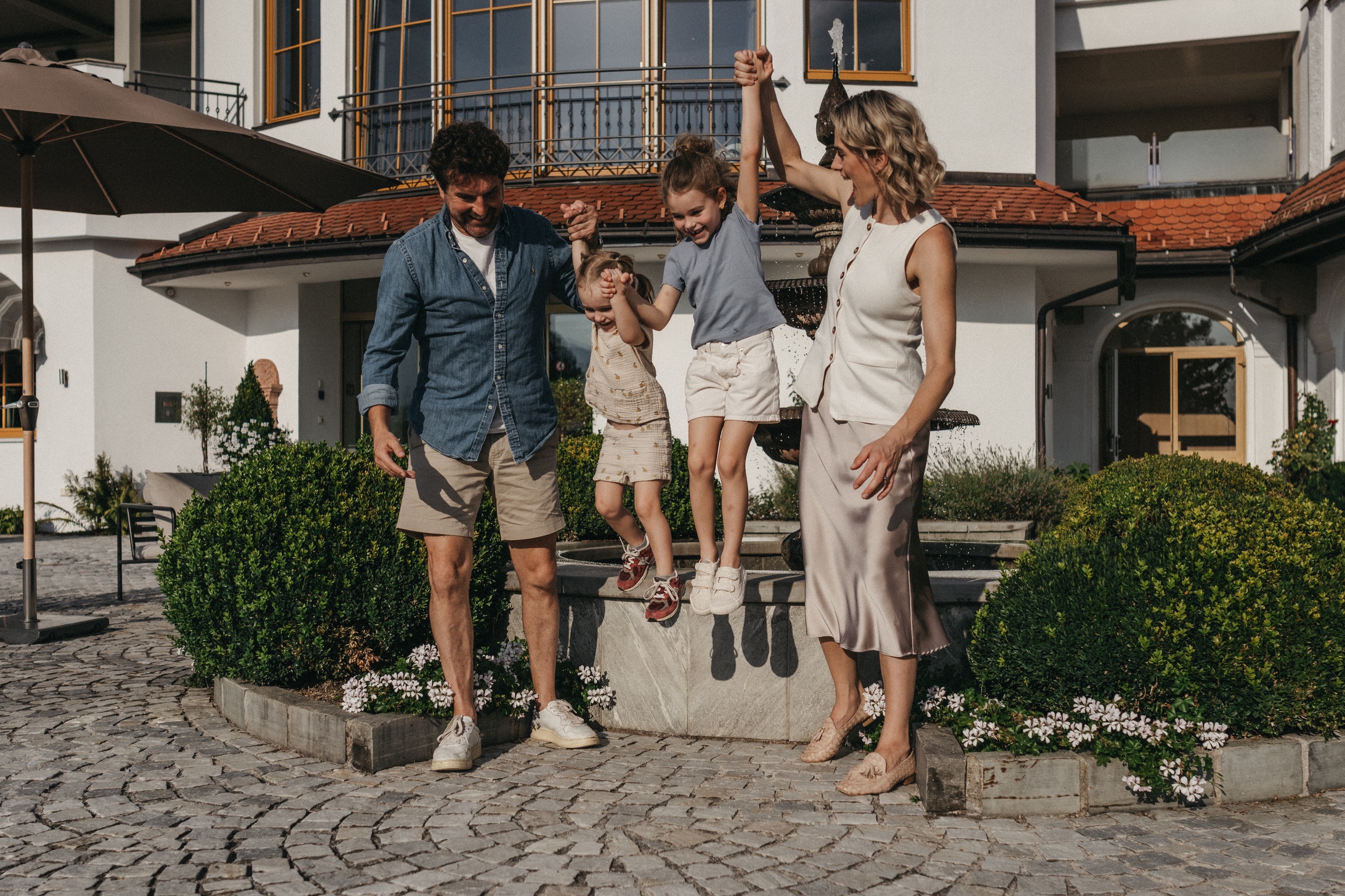 Familie auf der Terrasse im Hotel Alpina genießt die Sonne.