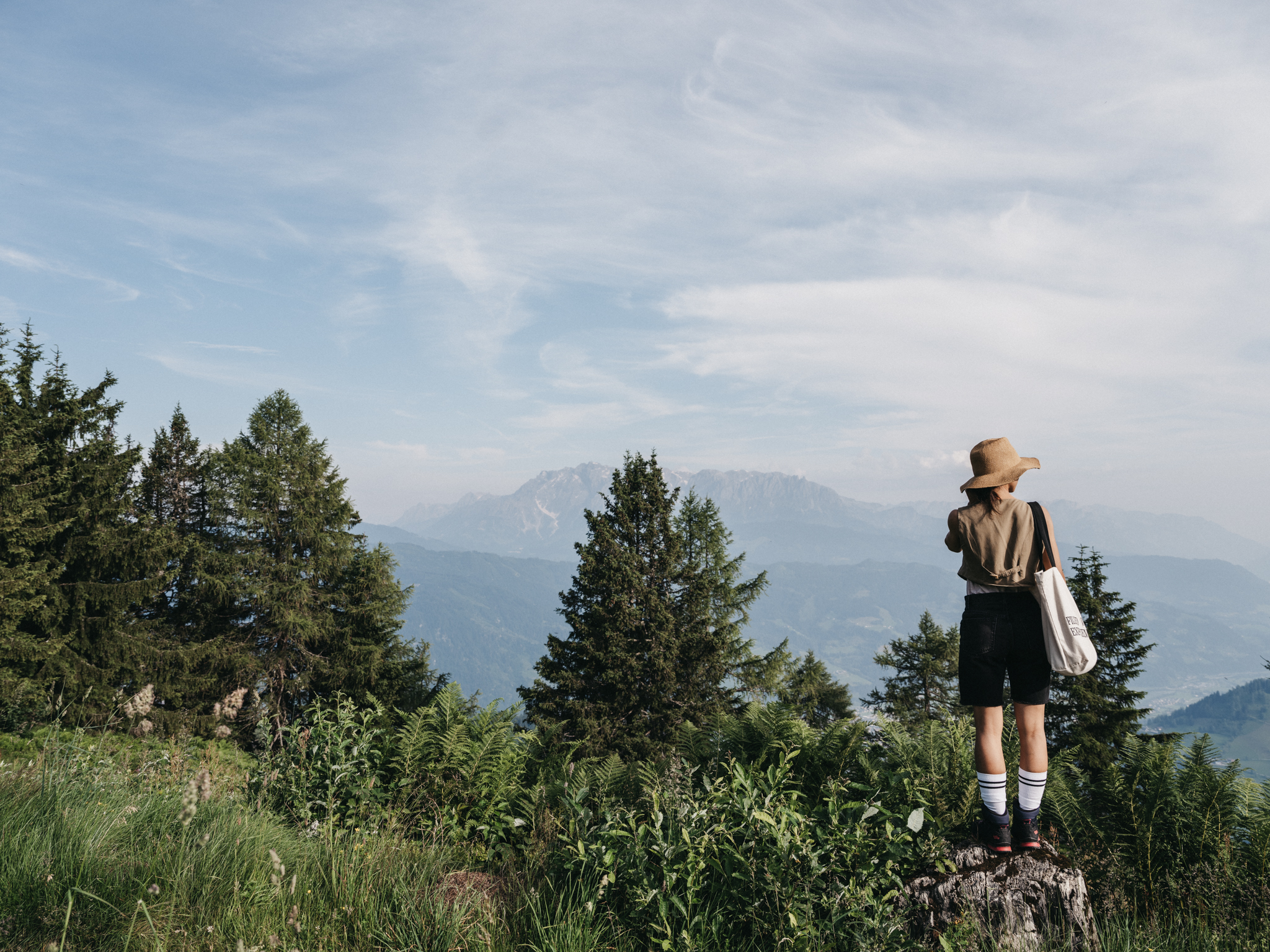 Eine Frau geniesst die Bergkulisse beim Wanderurlaub im Alpina Alpendorf.